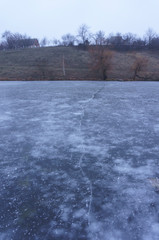 Ice on the lake and crack on the ice, concept of danger of the first ice
