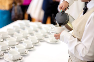 Obraz na płótnie Canvas Hotel breakfast service - waitress pouring coffee for guest