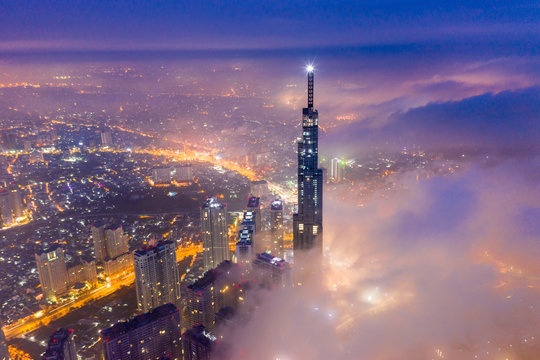 Aerial view of Saigon cityscape at night with misty sky