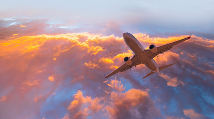 Airplane in the sky at sunset clouds