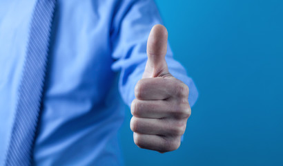 Businessman making a thumbs up gesture.