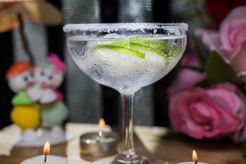 Delicious margarita cocktail with lime in a glass on dark background.