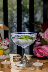 Delicious margarita cocktail with lime in a glass on dark background.