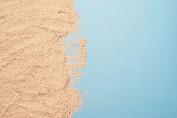 Sand beach on blue background copy space. Summer vacation concept. Top view.
