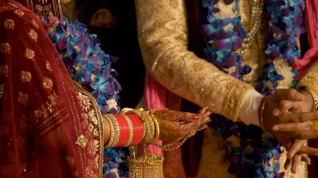 Shot of a man giving puffed rice in the bride's hands on her special wedding day. Beautiful bride in lehenga performing the last ritual in an Indian wedding  Bidaai spells out as 'goodbye' - sentim...