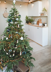 A beautiful living room decorated for Christmas. New Year interior. Decorated fir tree with garlands and balls, festive interior decorations
