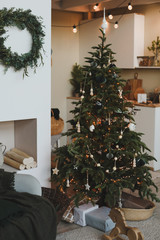 A beautiful living room decorated for Christmas. New Year interior. Decorated fir tree with garlands and balls, festive interior decorations