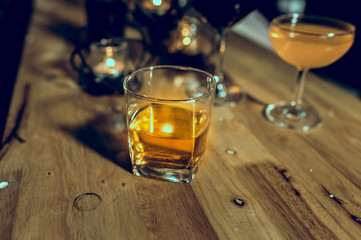 a glass of whiskey on wood bar, soft focus.