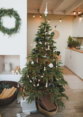 A beautiful living room decorated for Christmas. New Year interior. Decorated fir tree with garlands and balls, festive interior decorations