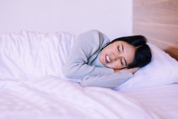Asian woman sleeping on bed and grinding teeth
