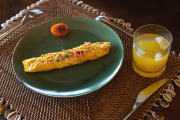 Tasty omelet on the plate and glass of orange juice