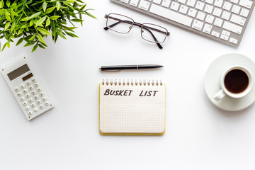 Bucket list. Blank notebook to write goals and wishes on white office desk top-down