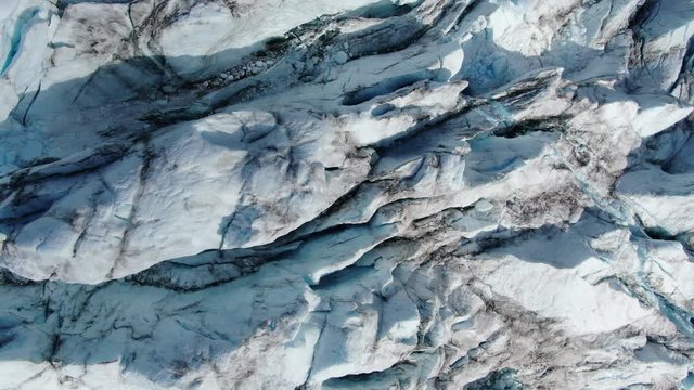 Slow and majestic aerial drone ascending view of the glacier of Sam Ford Fjord, Canada, near Greenland, with with high details of the glacier and the harsh rocky terrain