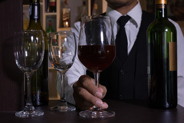The waitress was pouring a glass of red wine. 