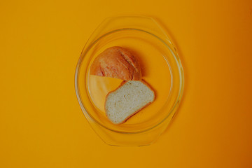 Diet and weight loss theme on the orange background. Bread on the glass plate.