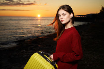 Fototapeta premium woman with suitcase at sunset