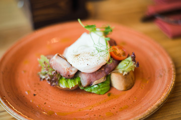 Breakfast in the restaurant - poached egg and bacon on toast