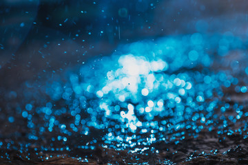 Autumn background with bokeh from the drops of rain, bright blue light is refracted through drops...