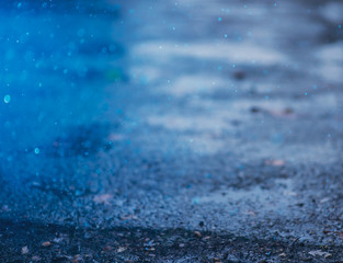 Autumn background with bokeh from the drops of rain, bright blue light is refracted through drops of water