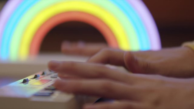 Soft focus side view of kids hands playing a small keyboard