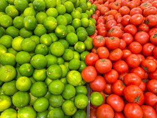 Pile of fresh limes and red tomatoes for healthy concept