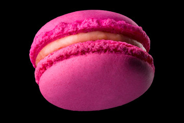 Macro photo of french pink rose macaroon isolated on black with clipping path