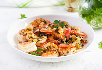 Grilled shrimps. King prawn tails in orange-garlic sauce with parsley.