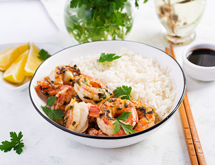 Grilled shrimps and boiled rice. King prawn tails in orange-garlic sauce with parsley.
