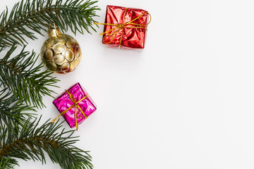 Top view of Christmas gift box red balls with spruce branches, pine cones, red berries and bell on white background.