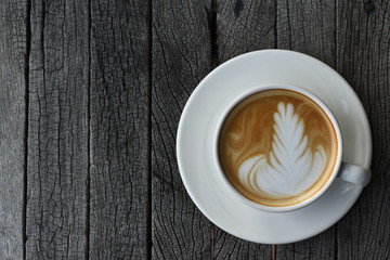 Close up a white coffee cup with heart shape on wood desk