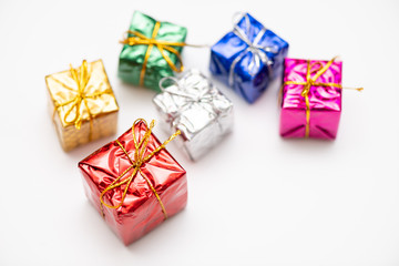 Merry Christmas card made of fir branches, gift boxes, red decoration, sparkles and confetti on white background.