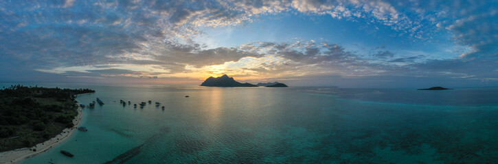 Aerial view of Sea Gypsy water village, island and the ocean with sky during sunrise in Semporna, Sabah, Malaysia, Borneo.
