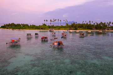 Aerial view of Sea Gypsy water village, island and the ocean with sky during sunrise in Semporna,...