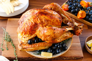 Roasted whole turkey on a table with fruits for family Christmas or Thanksgiving Holiday.