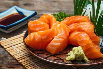 Sashimi, Salmon, Japanese food chopsticks and wasabi on the wood table