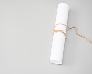 white paper rolls with packthread isolated on gray background, paper Blank portrait A4. brochure magazine. 