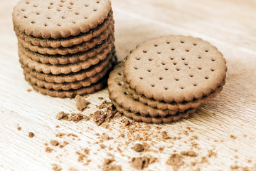 Crispy chocolate chip cookie with holes on a wooden board. Filled Round Cookies