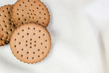 Crispy chocolate cinnamon with holes on a wooden board. Round biscuits with filling. space for text