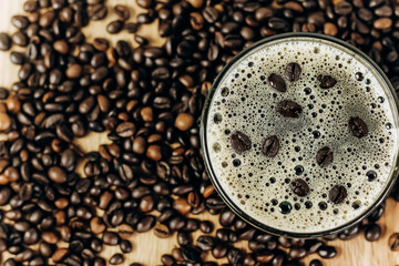 a lot of coffee beans on a wooden background. Cup of freshly brewed black coffee