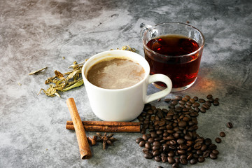 Hot coffee and hot tea with beans and tea leaves.