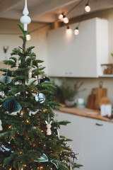 Festive kitchen in Christmas decorations. Christmas dining room. Beautiful New Year decorated classic home interior. New Year and Christmas background