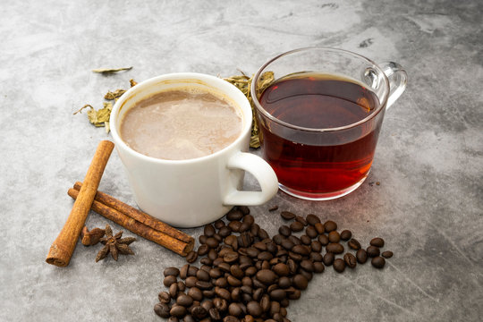 Hot coffee and hot tea with beans and tea leaves.