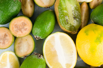 Juicy and ripe feijoa with lemon isolated on a mint background. Healthy autumn fruit.