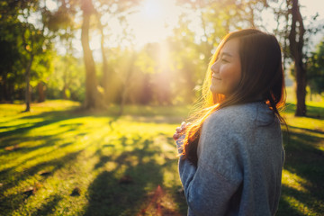 Portrait image of a beautiful asian woman standing among nature in the park before sunset - Powered by Adobe