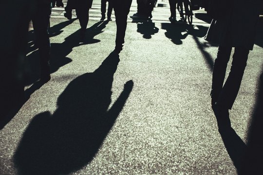 Shadow Of The People On The Asphalt Crossing The Street