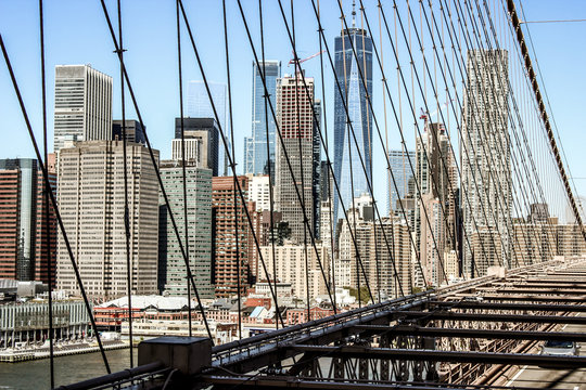 Cinematic look of the skyline of Lower Manhattan, New york. Taken from the Brooklyn Bridge with the steel cables crossing the image, United States of america.