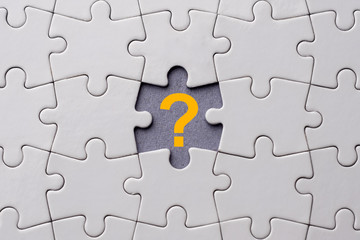 Orange question mark placed on last piece of jigsaw puzzle