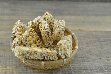 Cereal bars in bamboo basket on wooden background.