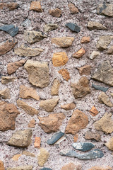 Old stone wall of stones of different sizes and colors as a natural background.