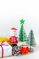 Christmas decoration concept. Santa Claus toy, gift box, pine cone and mini Christmas tree on the table. Decorative objects for Xmas and New Year holiday. Ornament for Festive season and celebration 